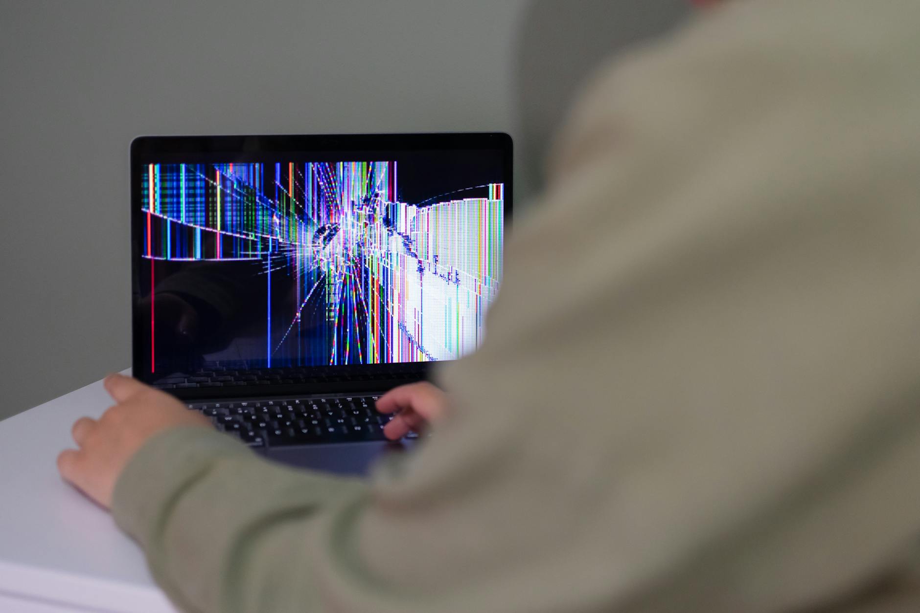 A technician using an infrared thermal imaging camera to map moisture behind a drywall partition in an Aurora basement.
